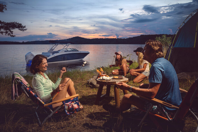 Family at a campsite next to an SDX 270 Outboard at twilight