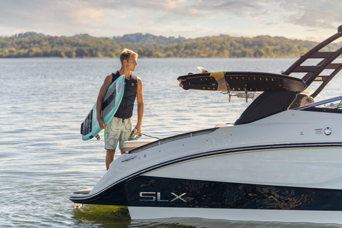 Man with wakesurf board on an SLX 260 Surf